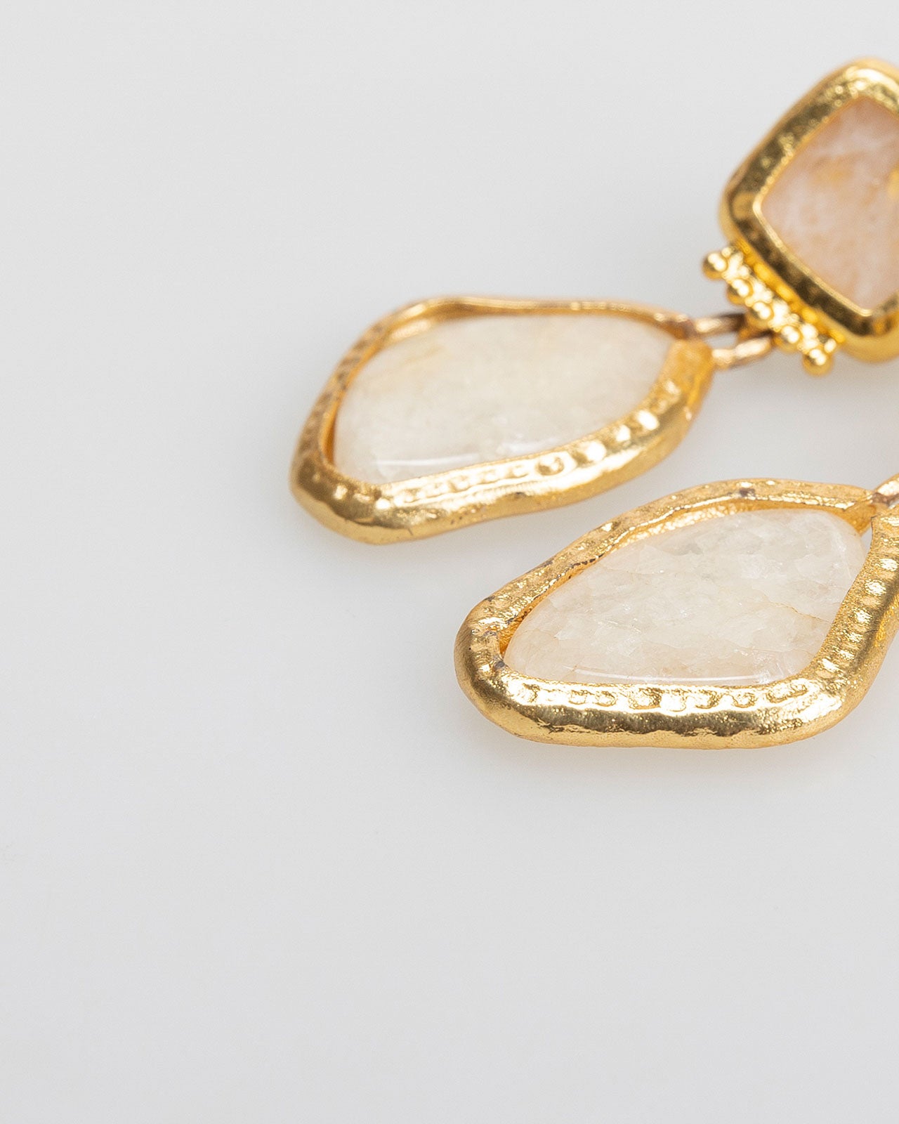 Asymmetrical gold earrings with marble effect rhinestones