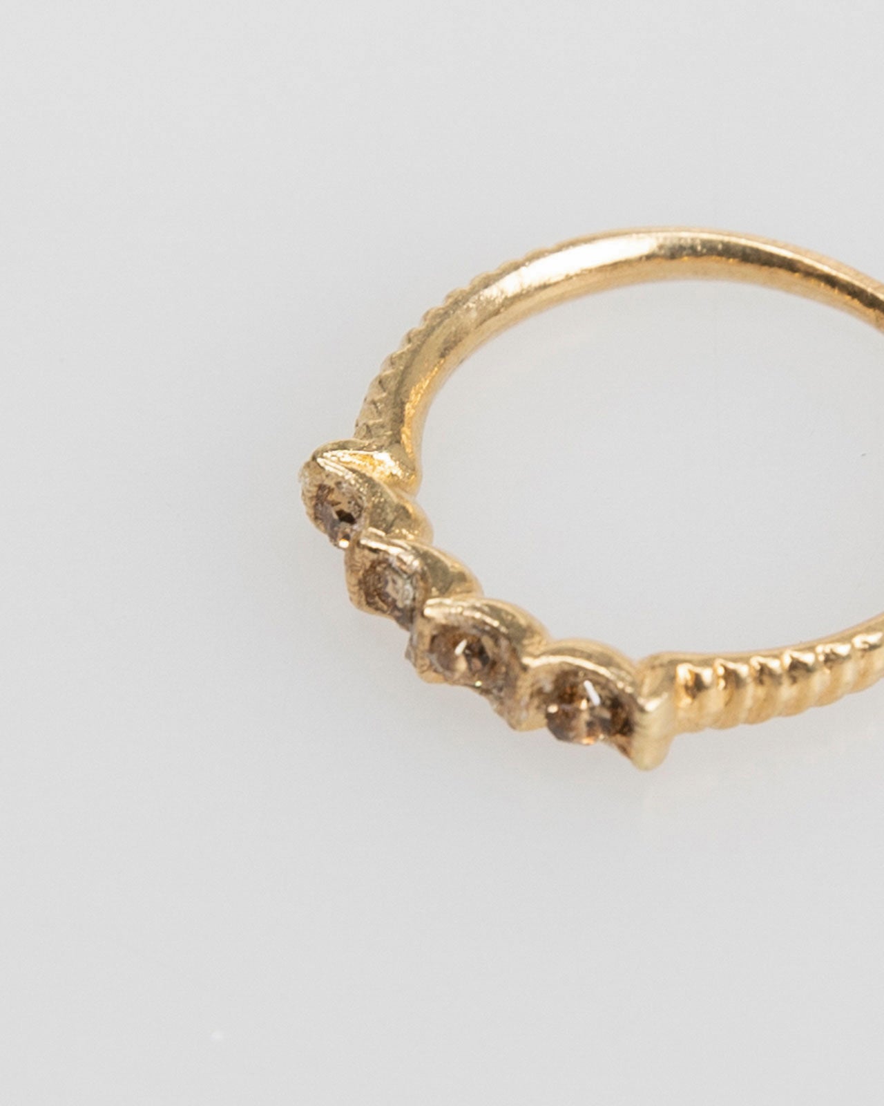 Thin gold-colored ring with colored rhinestones