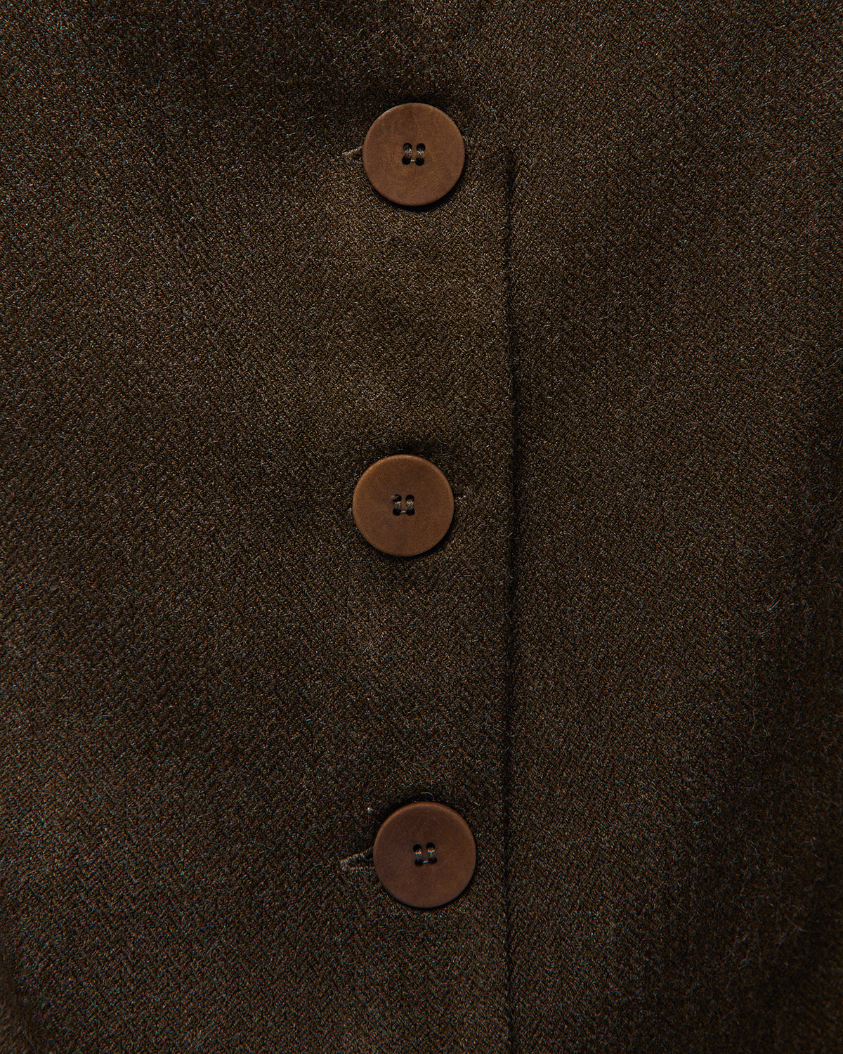Chaleco verde oscuro con pinzas delanteras, detalle del tejido